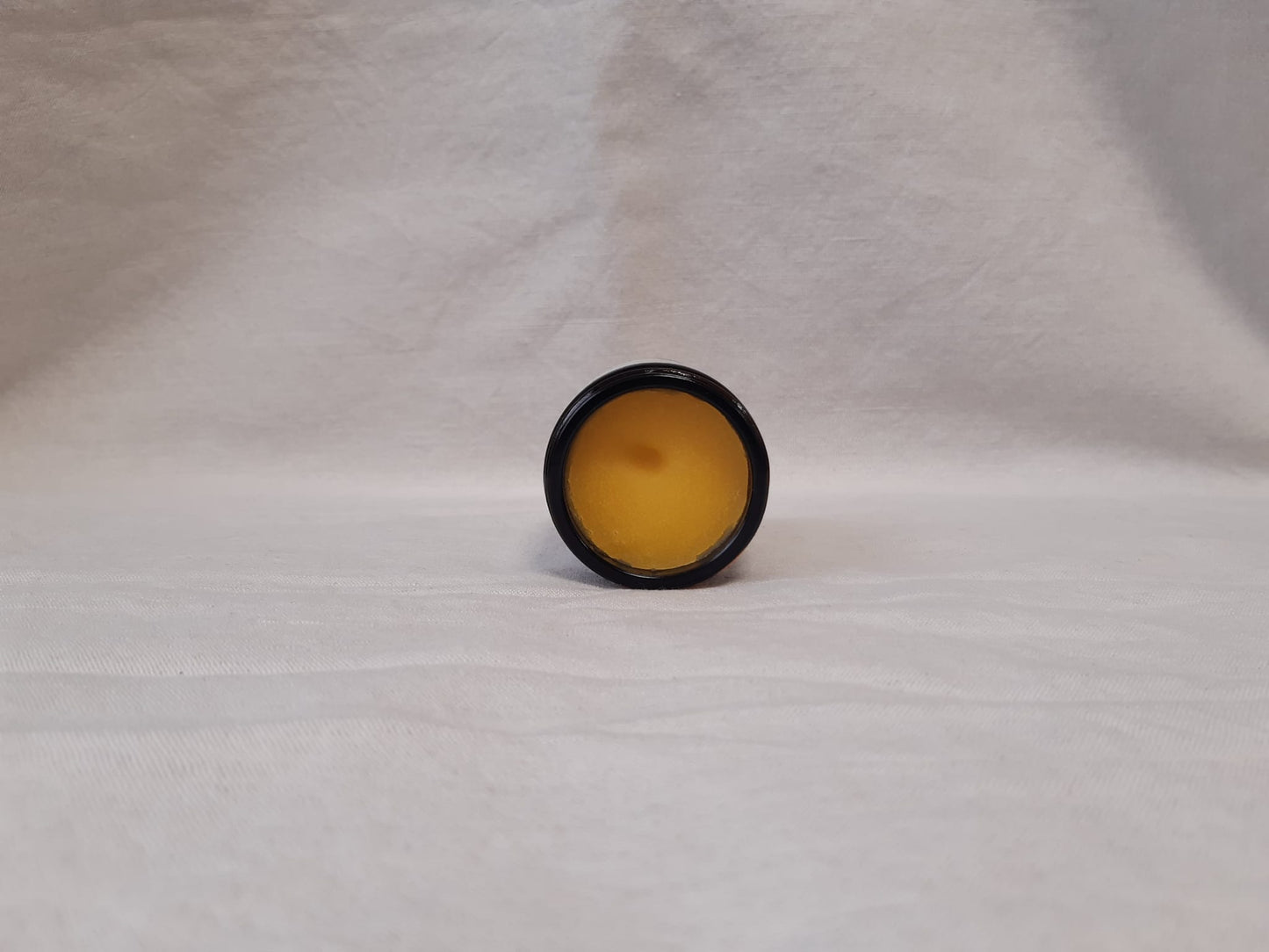 Open jar of Hyd Gentle Cleansing Balm on a grey background