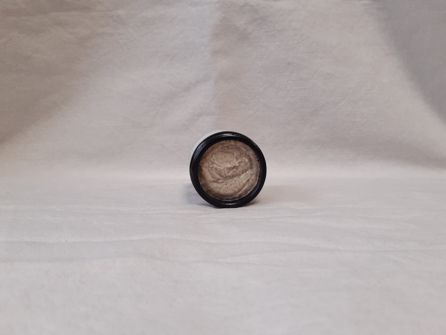 Jar of Hyd Glow Face Polish open on a grey background